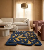 Abstract labyrinth hand-tufted area rug in navy blue and mustard yellow styled in a luxury neutral living room with cream sectional sofa, pink velvet armchair, arc floor lamp, and oak hardwood floor